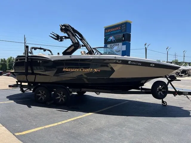 Slide: The Image of 2022 MasterCraft XStar S boat on trailer in parking lot, sunny day. - 6