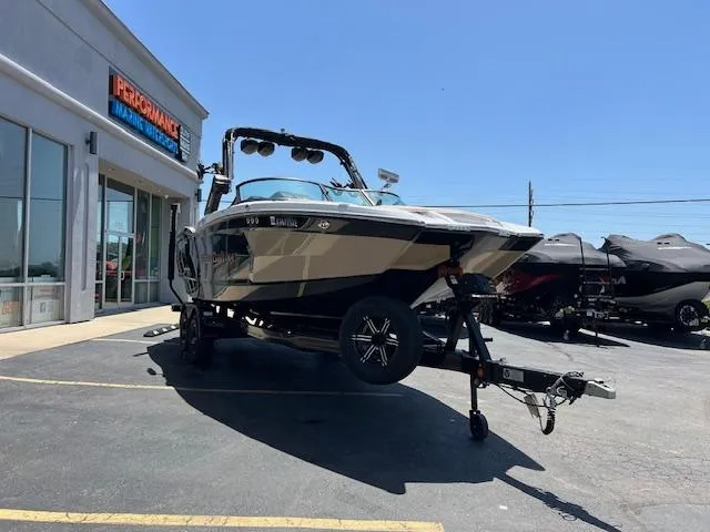 Slide: The Image of 2022 MasterCraft XStar S boat on trailer outside dealership under clear blue sky. - 7