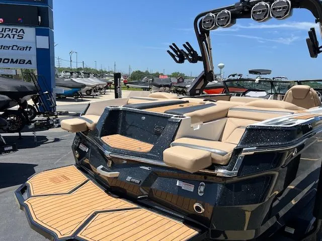 Slide: The Image of 2022 MasterCraft XStar S boat with luxurious seating and sleek design at a dealership. - 8