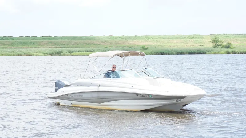 The Image of 2016 Crownline E4 boat cruising on a river with grassy banks in the background. - 1