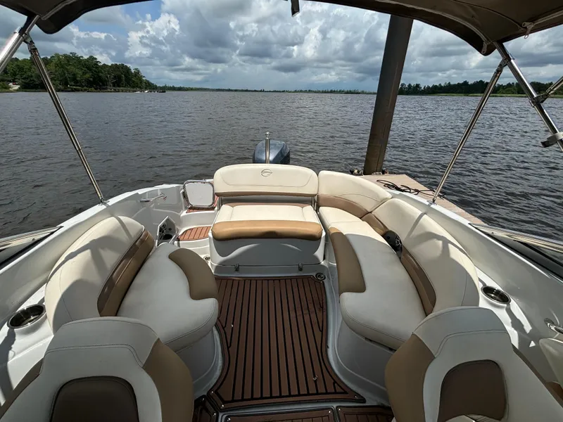 Slide: The Image of 2016 Crownline E4 boat interior with plush seating on a calm lake. - 13
