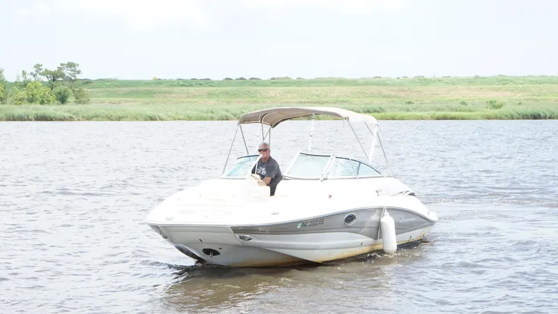 Slide: The Image of 2016 Crownline E4 boat cruising on a calm river with lush green banks. - 3