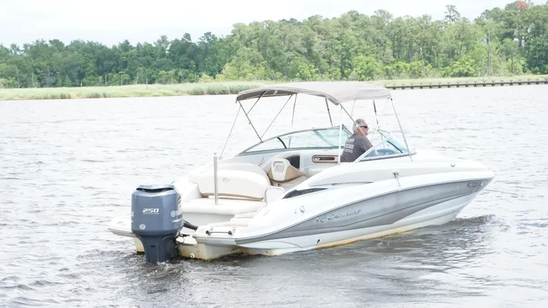 Slide: The Image of 2016 Crownline E4 boat cruising on a lake with lush green trees in the background. - 5