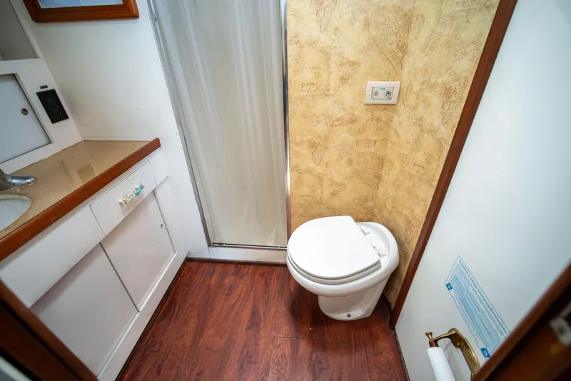 Slide: The Image of Bathroom interior of 1976 Bertram 42 Convertible yacht with wood flooring and compact design. - 10