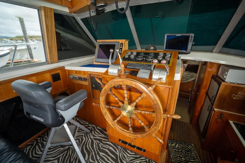 Slide: The Image of 1976 Bertram 42 Convertible helm with wooden wheel and modern navigation equipment. - 12