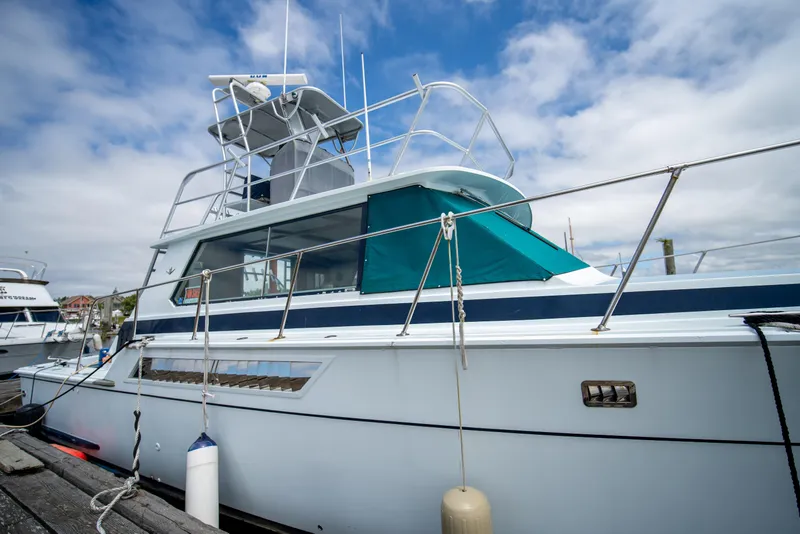 Slide: The Image of 1976 Bertram 42 Convertible yacht docked under a partly cloudy sky. - 16