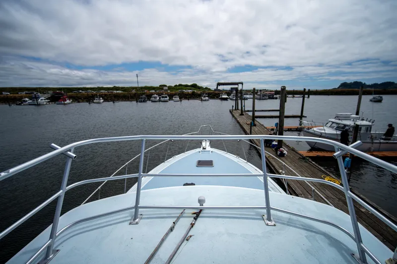Slide: The Image of 1976 Bertram 42 Convertible yacht docked at a marina under cloudy skies. - 18