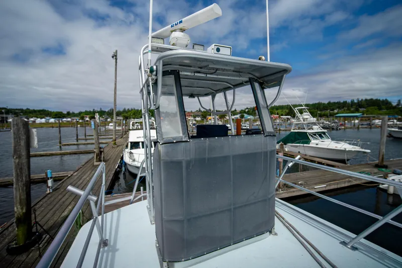Slide: The Image of 1976 Bertram 42 Convertible yacht docked at a marina under a cloudy sky. - 19
