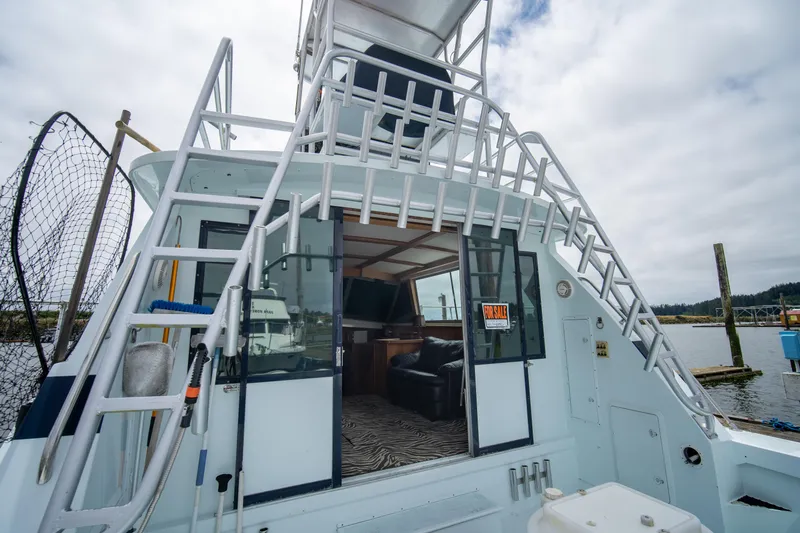 Slide: The Image of 1976 Bertram 42 Convertible boat with ladder, open cabin, and "For Sale" sign at dock. - 3