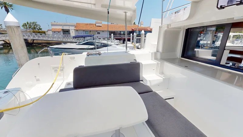 Slide: The Image of Spacious deck of 2020 Lagoon 46 catamaran docked at marina, featuring comfortable seating. - 10