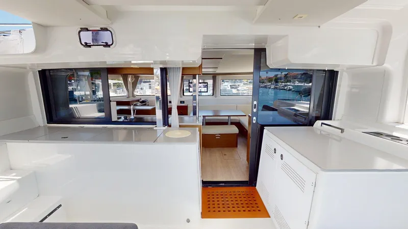 Slide: The Image of Interior of 2020 Lagoon 46 catamaran, featuring modern kitchen and dining area with marina view. - 12