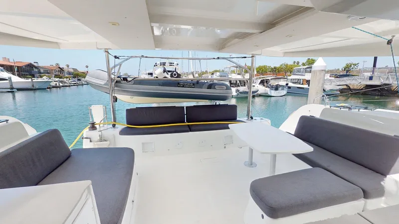 Slide: The Image of Spacious deck of 2020 Lagoon 46 catamaran with seating and table, docked at marina. - 14