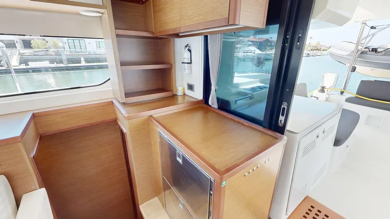 Slide: The Image of Interior of 2020 Lagoon 46 yacht with wooden cabinetry and marina view. - 16