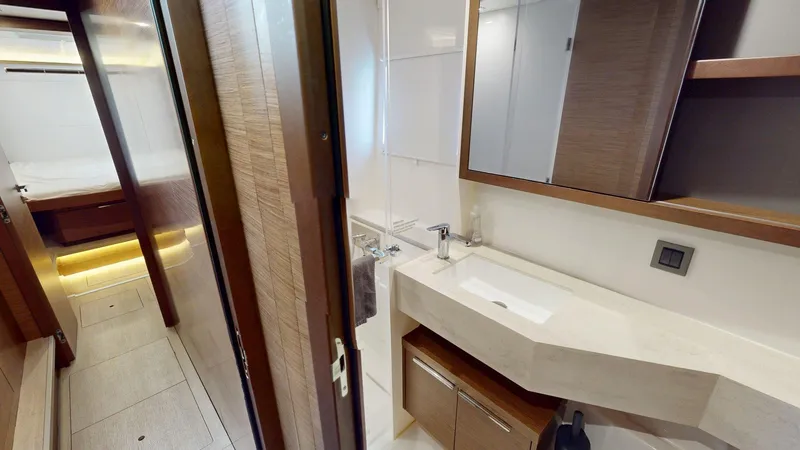 Slide: The Image of Modern bathroom interior on a 2020 Lagoon 46 yacht, featuring sleek wood and white finishes. - 17