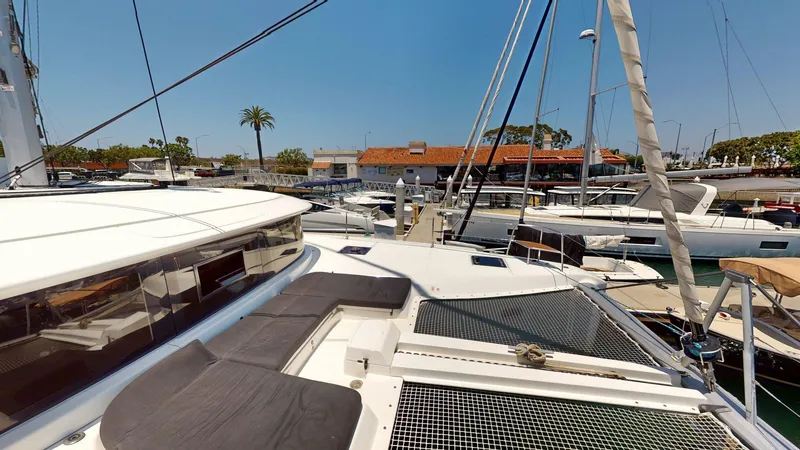 Slide: The Image of 2020 Lagoon 46 catamaran docked at marina, featuring spacious deck and modern design. - 21