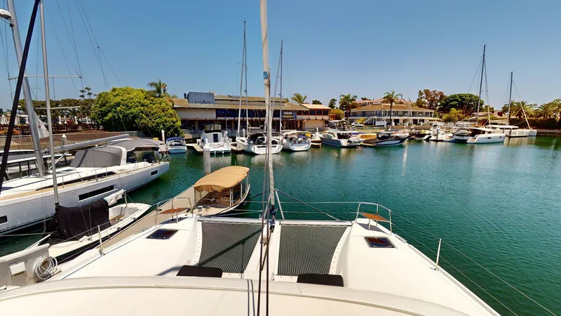 Slide: The Image of Lagoon 46 catamaran docked in a marina with surrounding boats, 2020 model. - 25
