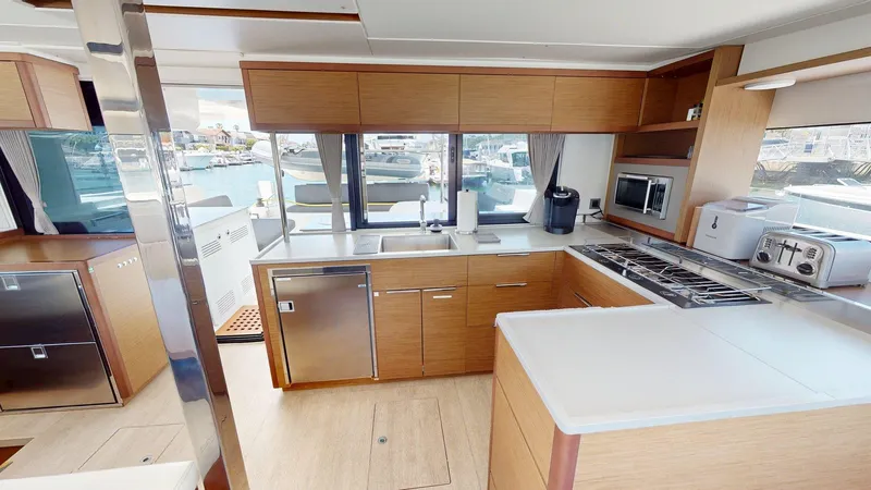 Slide: The Image of Modern kitchen interior of 2020 Lagoon 46 yacht with appliances and wooden cabinetry. - 5