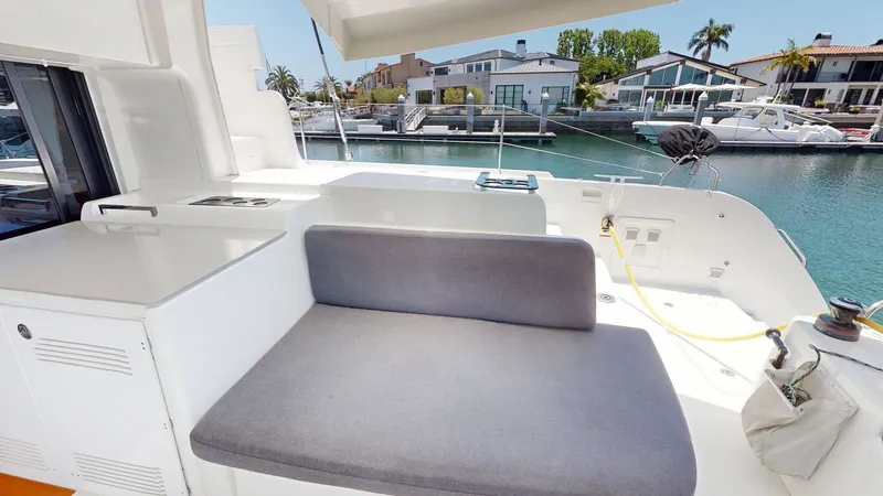 Slide: The Image of 2020 Lagoon 46 yacht deck with seating, docked in a marina with waterfront homes. - 9