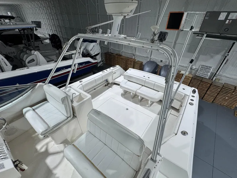 Slide: The Image of 2005 Stamas 310 Express boat interior with white seating and equipment in a storage facility. - 15