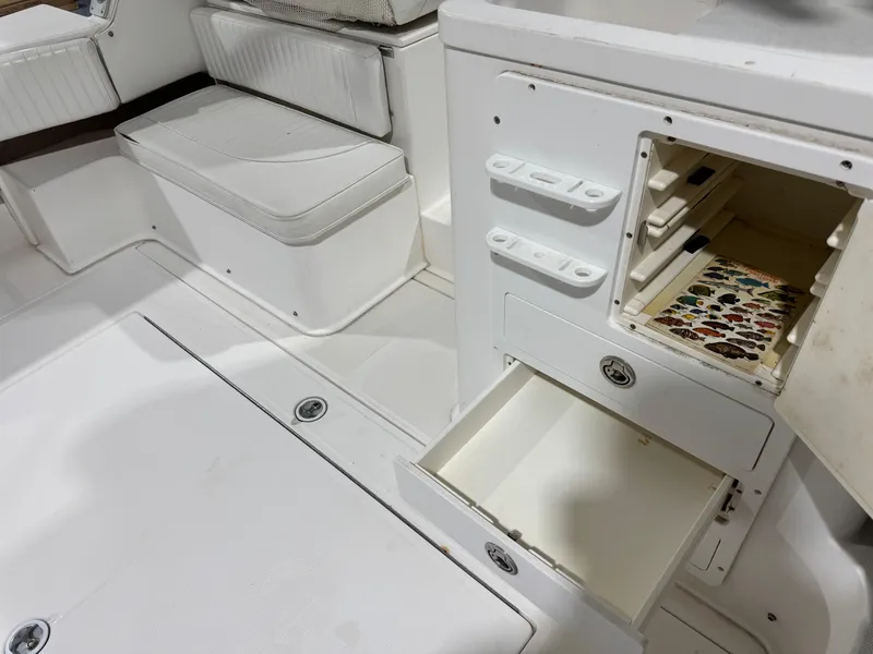 Slide: The Image of 2005 Stamas 310 Express boat interior with open storage compartments and seating. - 17