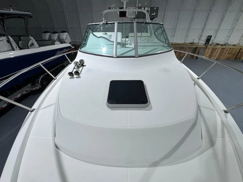 Slide: The Image of 2005 Stamas 310 Express boat in indoor storage, showcasing sleek deck and windshield. - 18