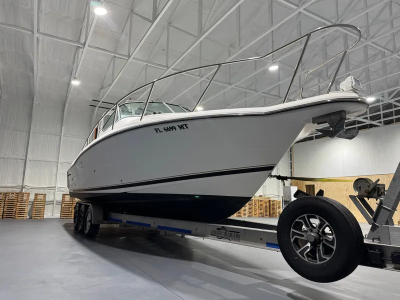 Slide: The Image of 2005 Stamas 310 Express boat on trailer in indoor storage facility. - 2