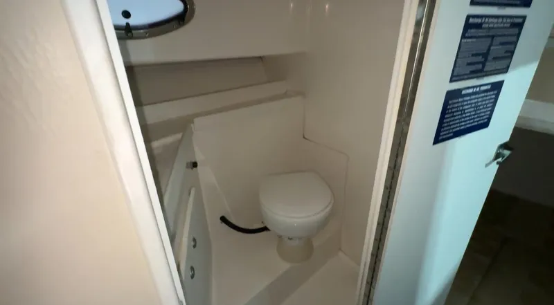 Slide: The Image of 2005 Stamas 310 Express boat bathroom interior with toilet and porthole. - 23
