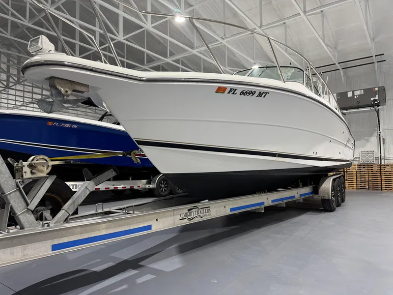Slide: The Image of 2005 Stamas 310 Express boat on trailer in indoor storage facility. - 3