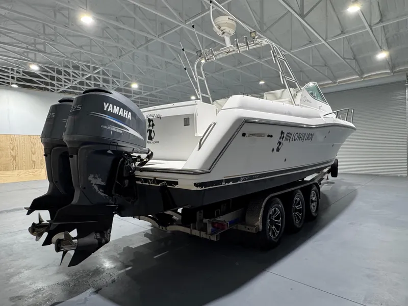 Slide: The Image of 2005 Stamas 310 Express boat with Yamaha engines on a trailer in a warehouse. - 5