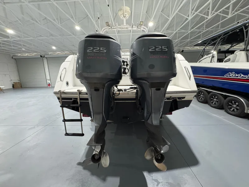 Slide: The Image of 2005 Stamas 310 Express boat with twin 225 horsepower engines in a spacious indoor marina. - 6
