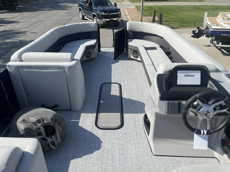 Slide: The Image of 2025 Harris Cruiser 250 pontoon boat interior with spacious seating and modern steering console. - 2