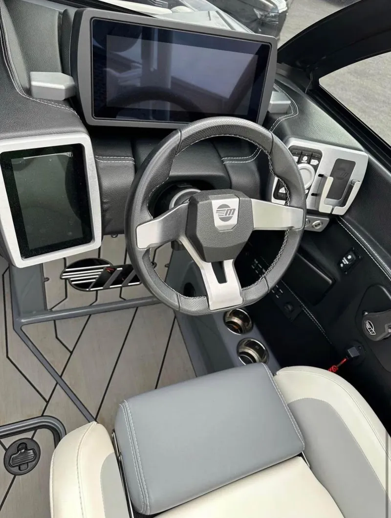 Slide: The Image of 2020 Malibu Wakesetter 24 MXZ dashboard with modern steering and touchscreen displays. - 6
