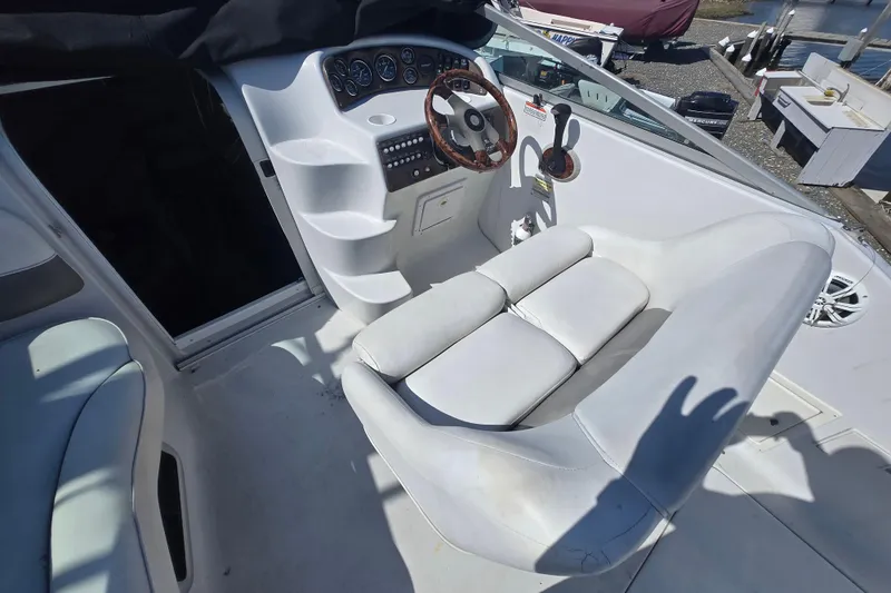 Slide: The Image of 2003 Crownline 262 CR boat cockpit with white seating and steering wheel. - 28