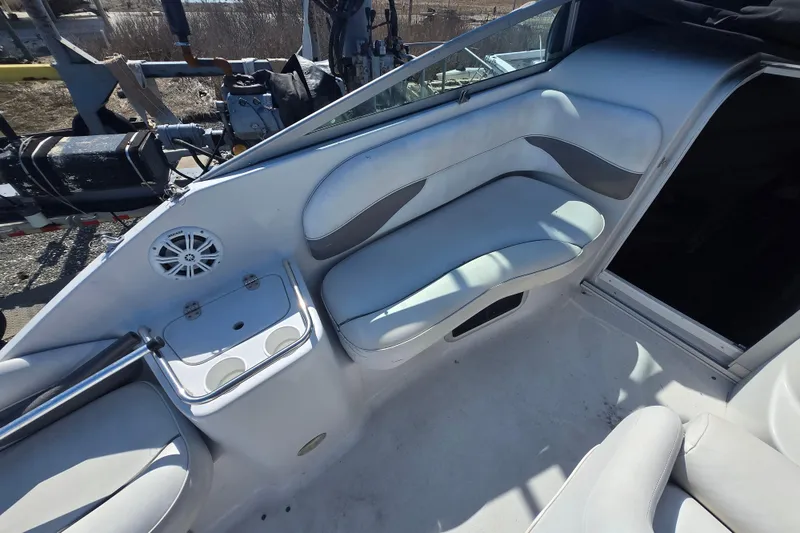 Slide: The Image of 2003 Crownline 262 CR boat interior with white seating and cup holders. - 29