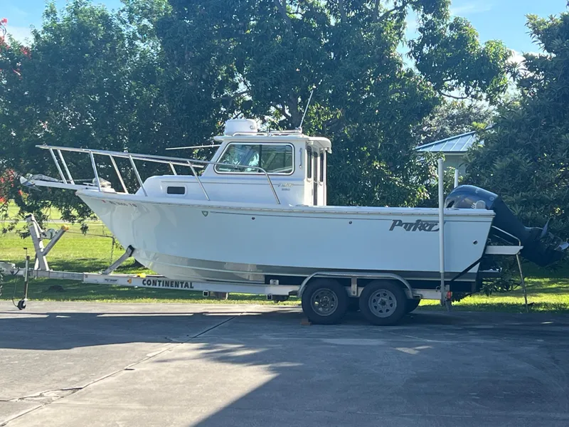 The Image of 2021 Parker 2120 boat on trailer, parked outdoors with lush greenery background. - 1