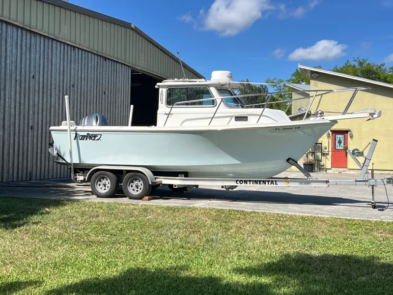 Slide: The Image of 2021 Parker 2120 boat on trailer outside metal building, sunny day. - 17