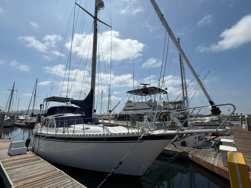 Slide: The Image of 1985 Nauticat 43 sailboat docked at marina under a partly cloudy sky. - 1