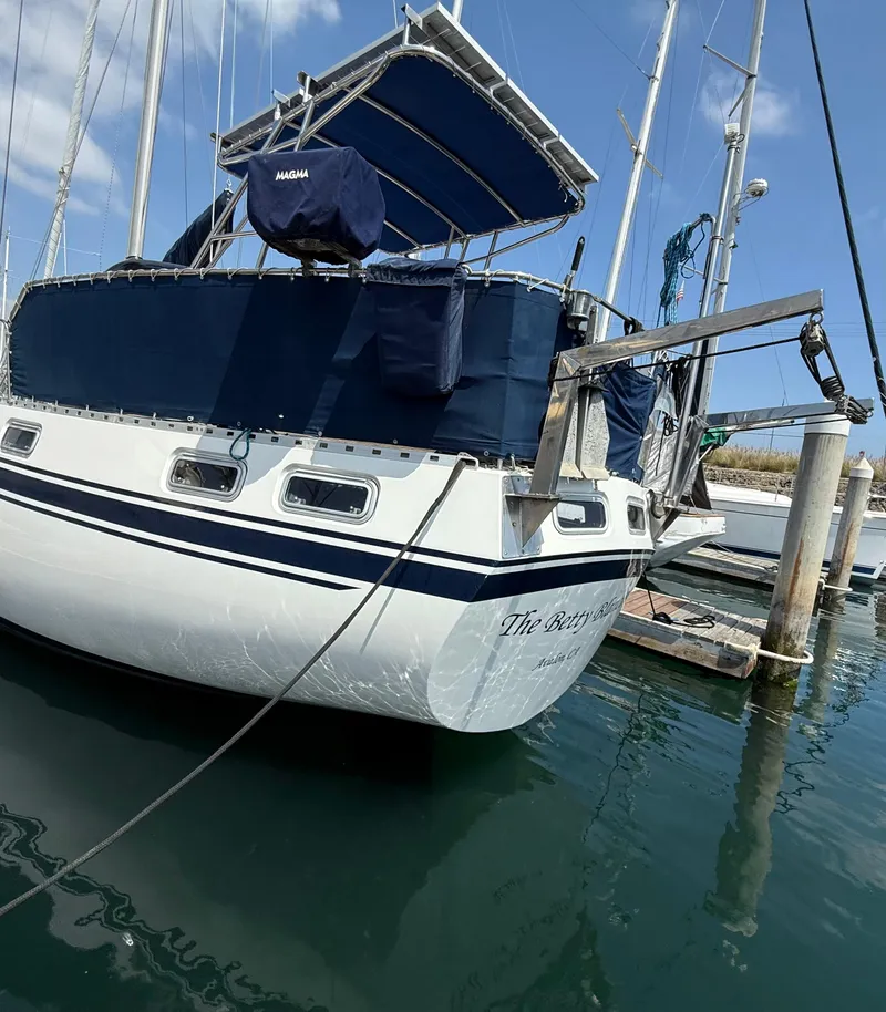 Slide: The Image of 1985 Nauticat 43 sailboat docked, featuring blue canvas covers and stainless steel fittings. - 2