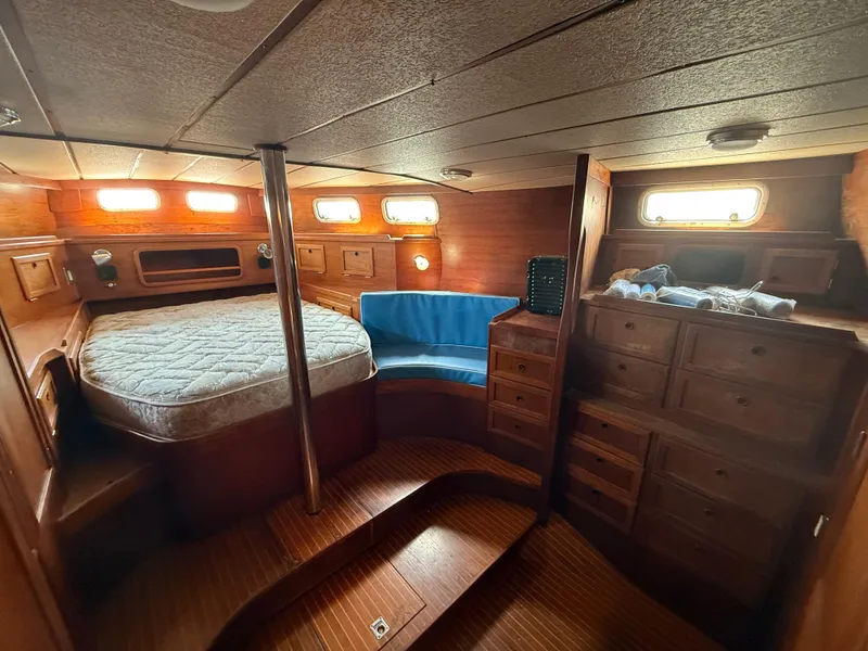 Slide: The Image of Cozy cabin interior of 1985 Nauticat 43 sailboat with bed, seating, and wooden storage. - 21