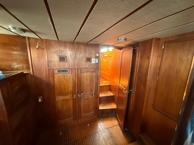Slide: The Image of Interior of 1985 Nauticat 43 sailboat, featuring wooden paneling and stairs to upper deck. - 26