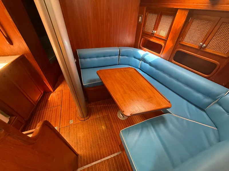Slide: The Image of Interior of 1985 Nauticat 43 yacht with blue seating and wooden table. - 27