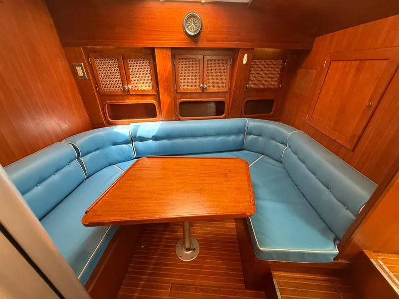 Slide: The Image of Interior of 1985 Nauticat 43 sailboat with blue cushioned seating and wooden table. - 28