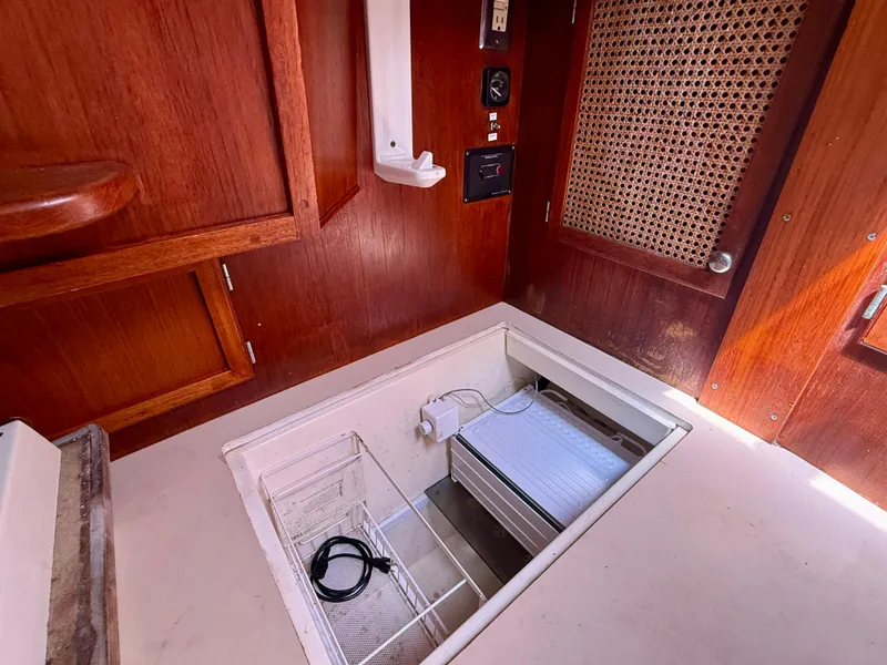 Slide: The Image of 1985 Nauticat 43 interior with wooden cabinetry and open storage compartment. - 29