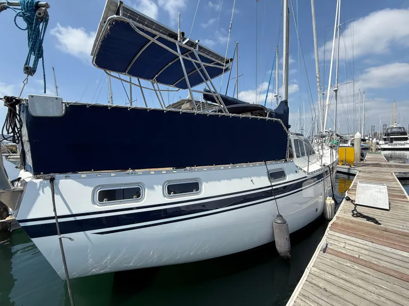 Slide: The Image of 1985 Nauticat 43 sailboat docked at marina under clear blue sky. - 3