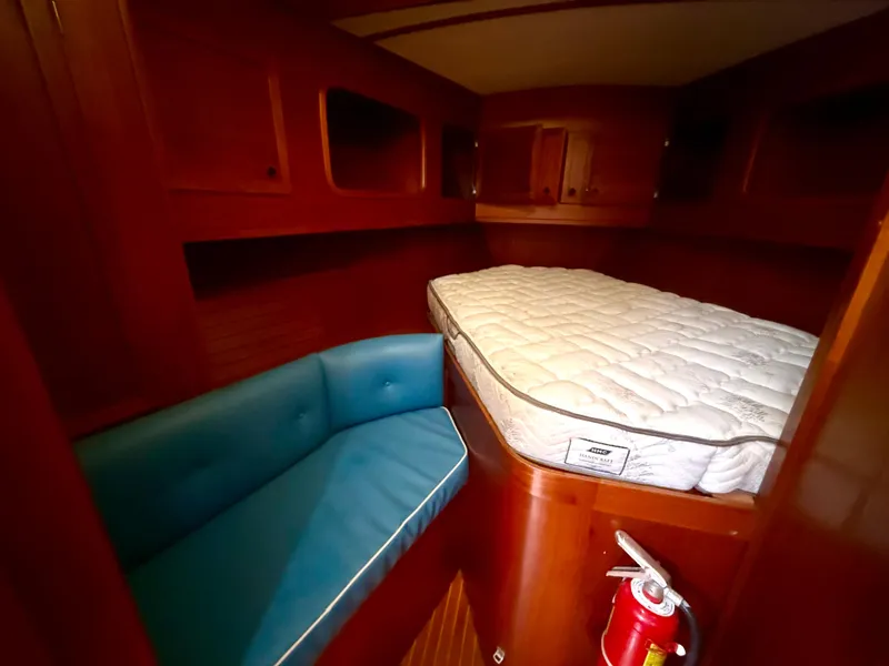 Slide: The Image of Cozy cabin interior of 1985 Nauticat 43 with bed, blue seating, and fire extinguisher. - 31