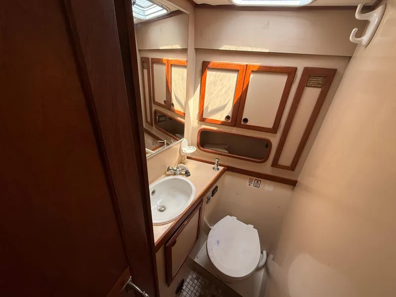 Slide: The Image of Bathroom interior of 1985 Nauticat 43 yacht, featuring sink, toilet, and wooden cabinetry. - 32