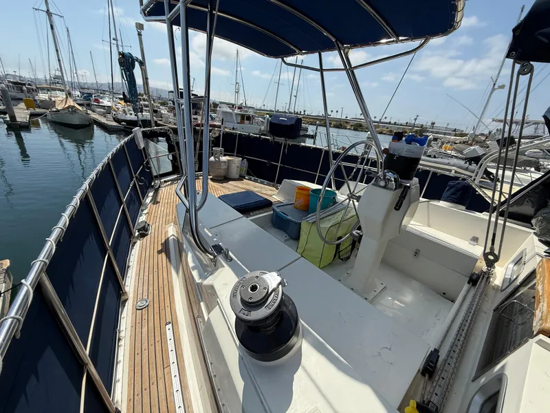Slide: The Image of 1985 Nauticat 43 sailboat deck with steering wheel, docked in marina. - 4