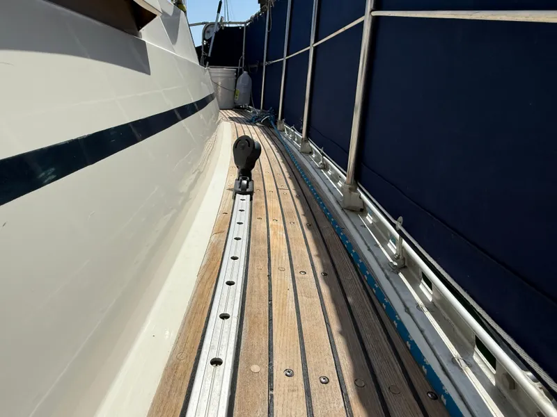 Slide: The Image of Side deck of 1985 Nauticat 43 sailboat with wooden planks and metal railing. - 5