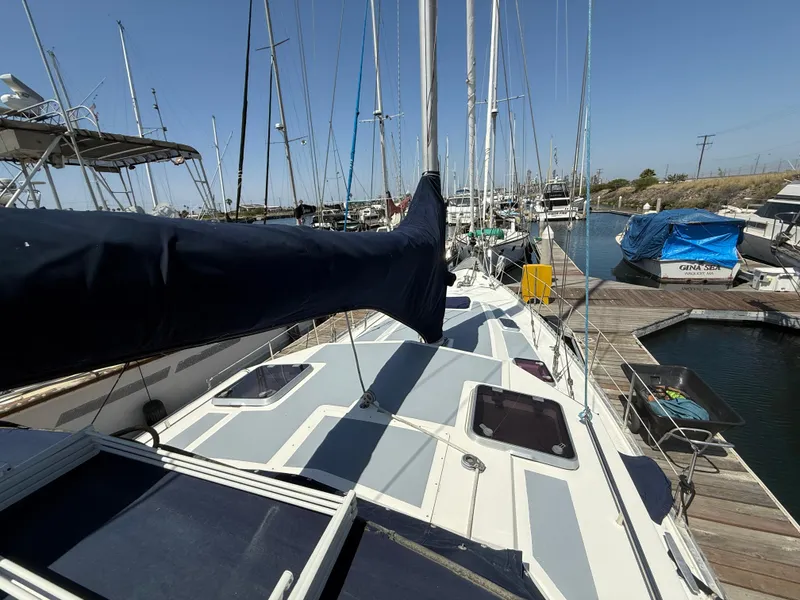 Slide: The Image of 1985 Nauticat 43 sailboat docked at marina, showcasing deck and mast under clear blue sky. - 9