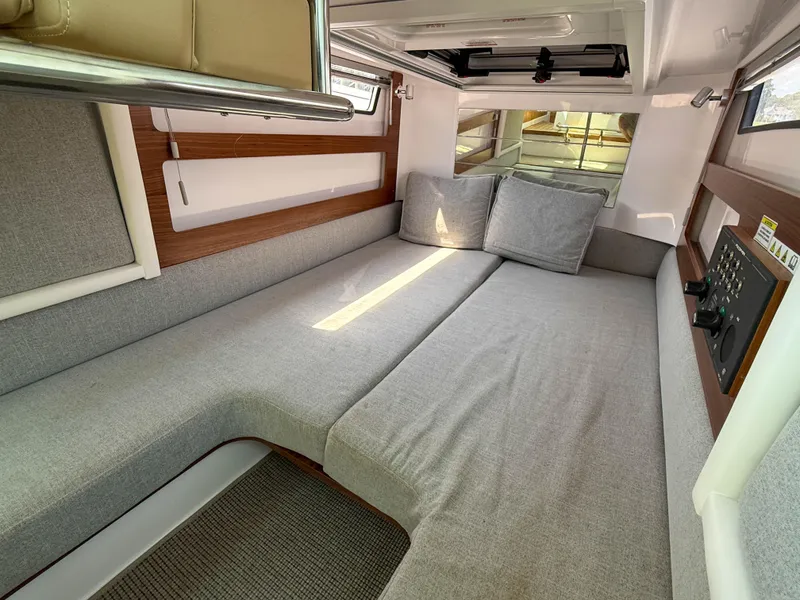 Slide: The Image of 2021 Axopar 28 CABIN interior with gray seating and wooden accents. - 13